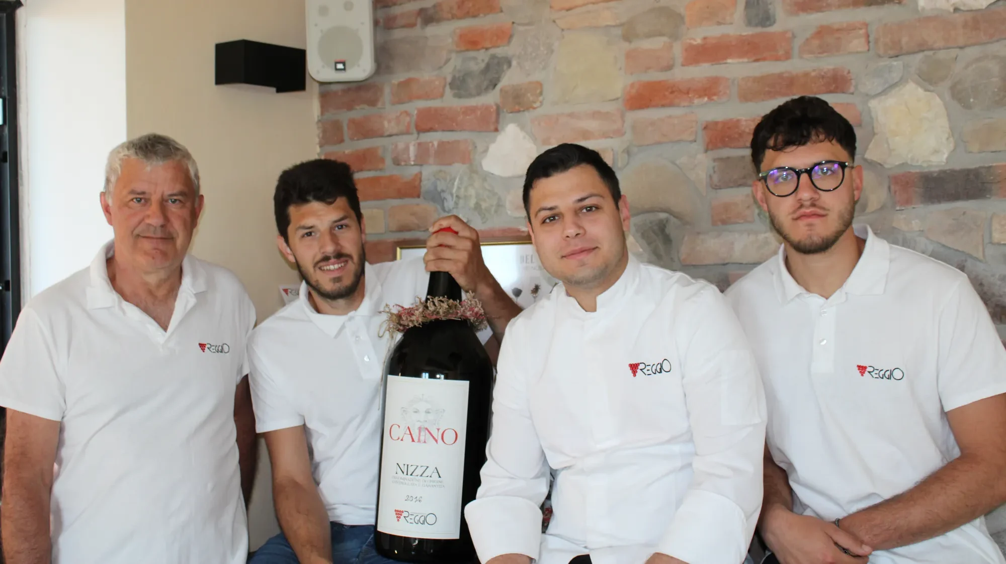 Il team di Cascina Reggio a Castelnuovo Calcea con una bottiglia magnum di Nizza DOCG Caino